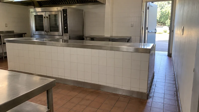 Find a fixed obstruction before attempting equipment removal A fixed counter interrupts the floor route from a commercial oven to the service doorway