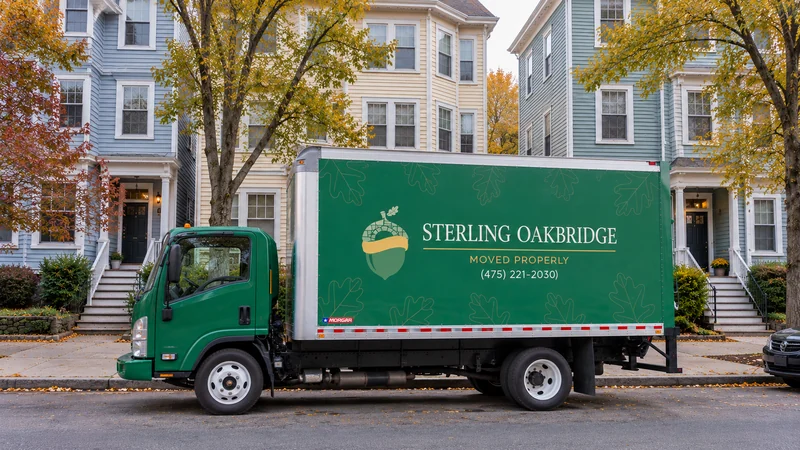 Review the vehicle position, building entrance and carrying route before confirming pickup. A green moving truck at representative Cambridge residential frontage