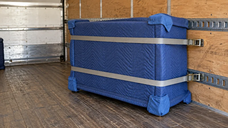 A dresser protected in quilted blankets and secured inside a stationary cargo bay A dresser protected in quilted blankets and secured inside a stationary cargo bay