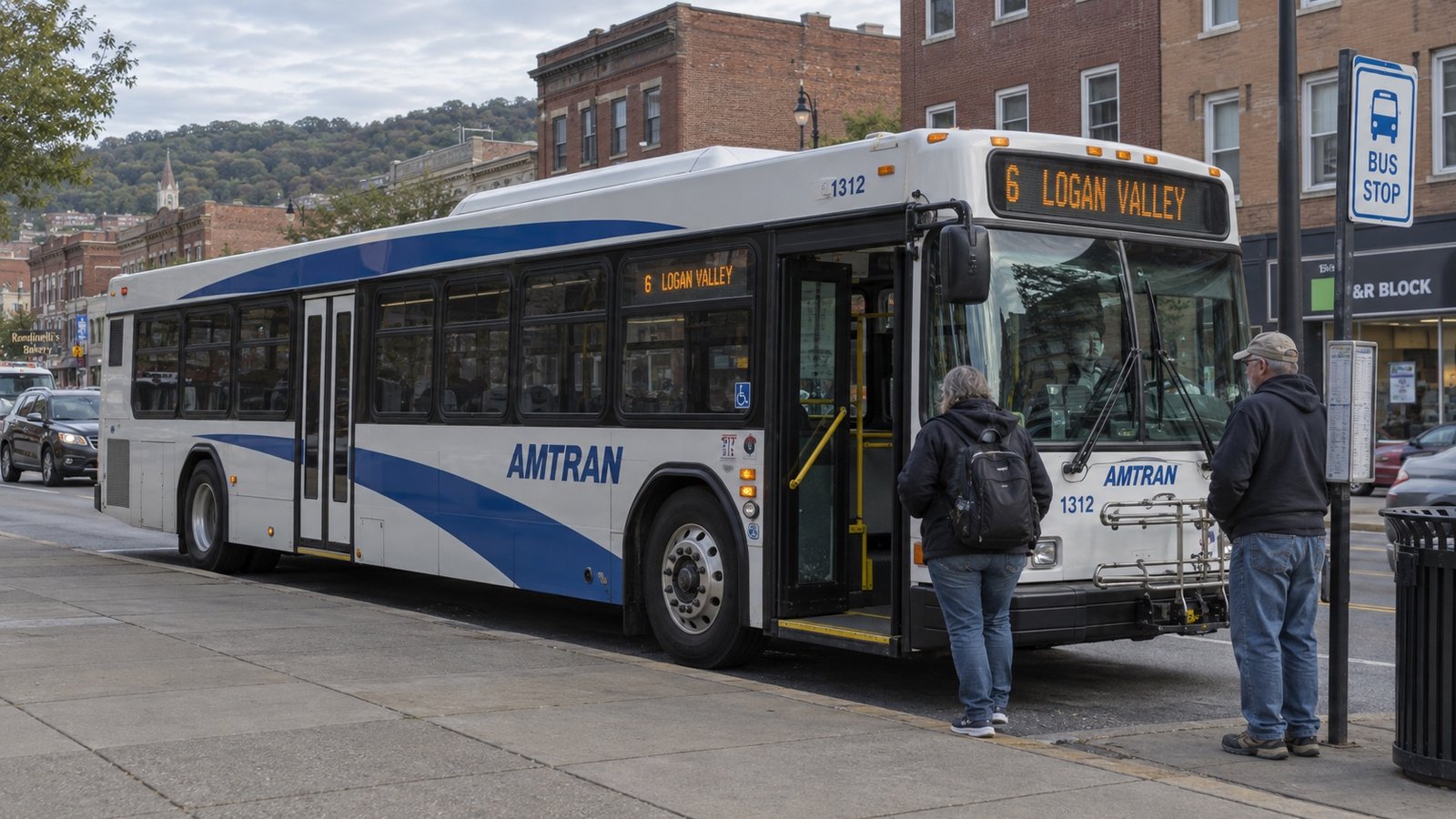 Full-size transit bus at a sidewalk stop with both wheels and two passenger doorways visible