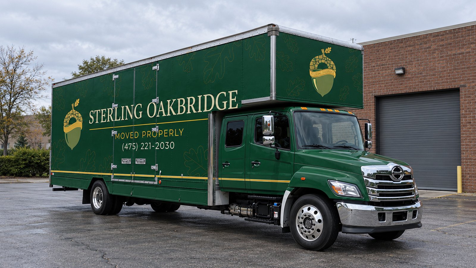 Space for the vehicle and its approach Dark green Sterling Oakbridge Hino box truck on a paved forecourt beside a brick building