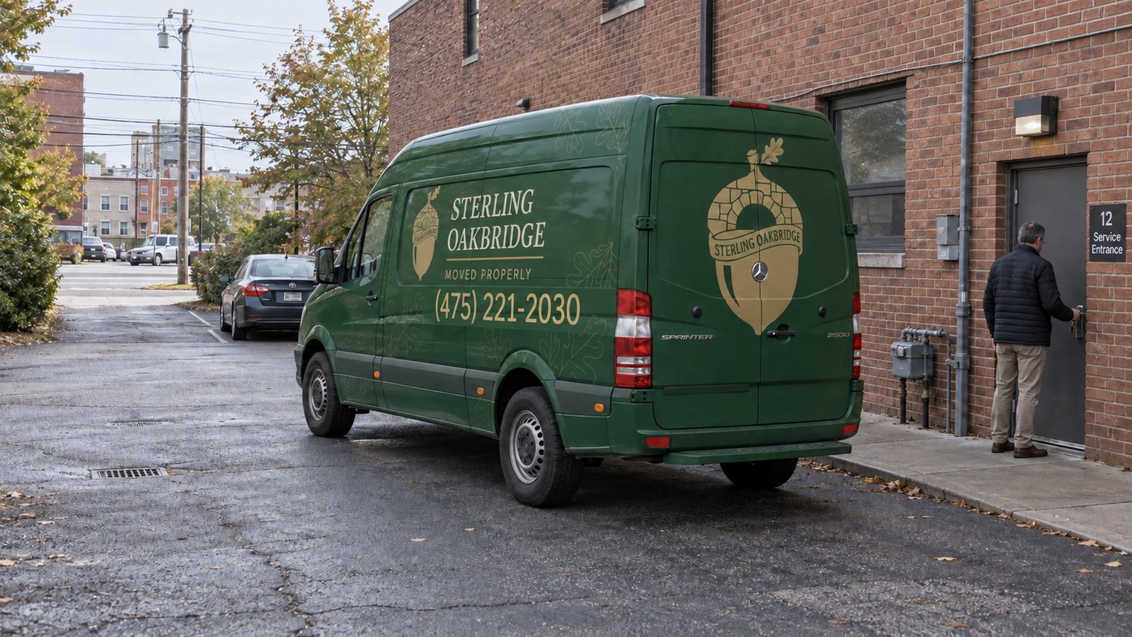 Green Sterling Oakbridge van behind a brick building, with a man unlocking the service entrance.
