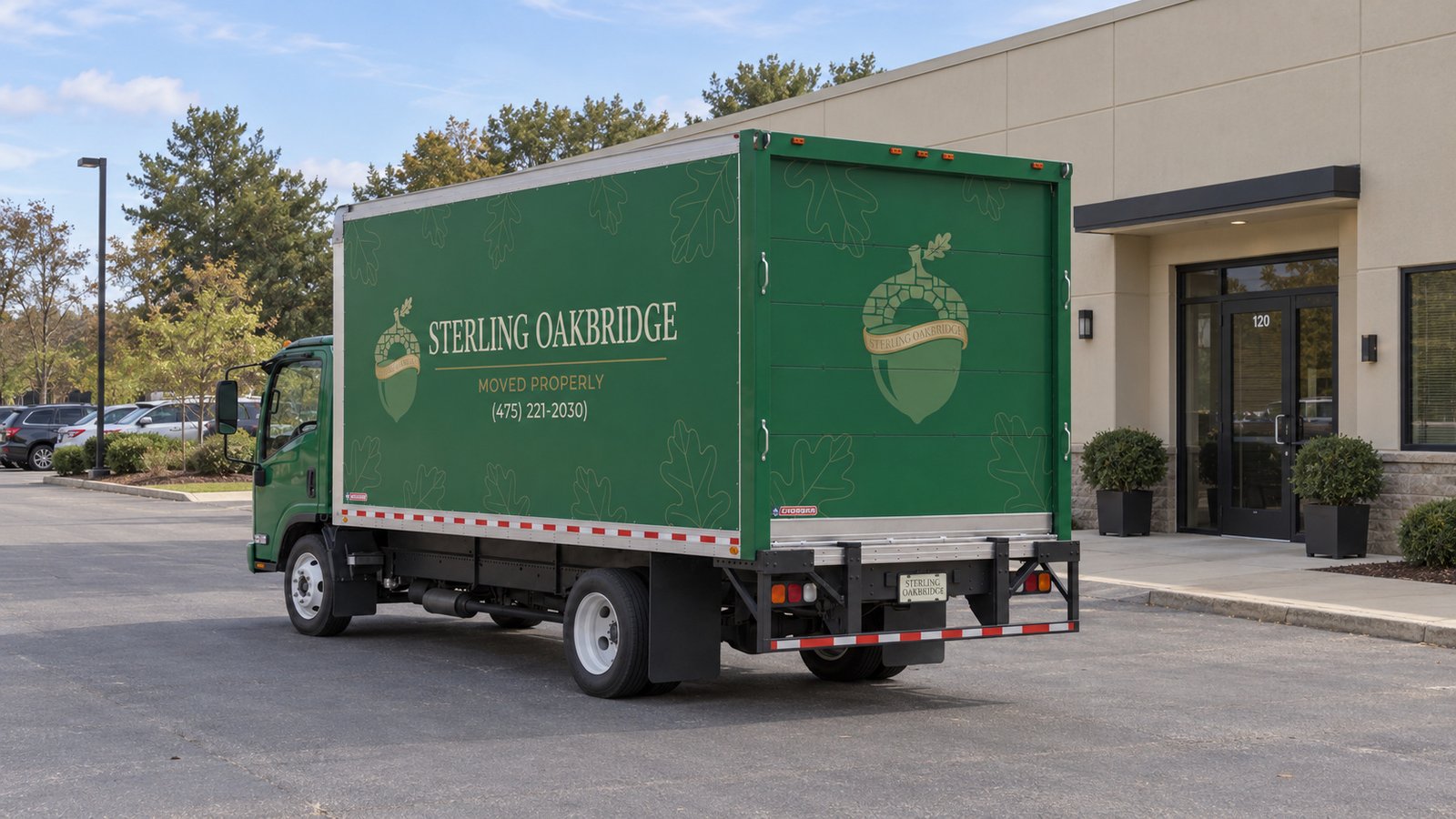 Confirm the truck position A whole green Sterling Oakbridge Isuzu NPR16 truck on a private paved commercial apron.