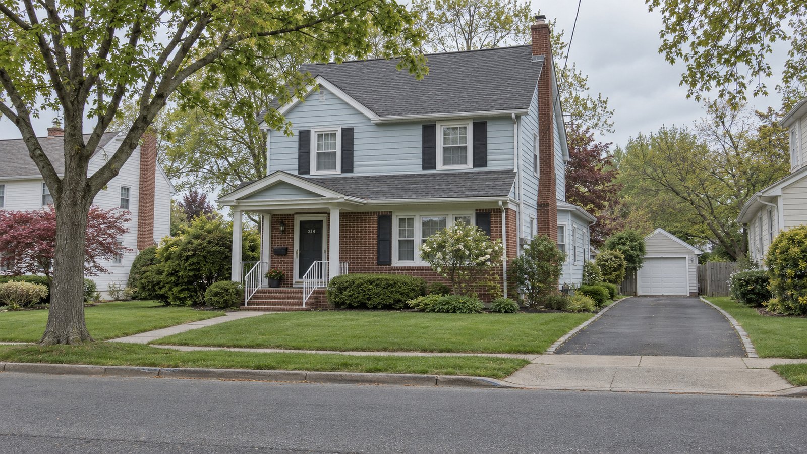 Assess the outside approach A whole pale-blue two-story house with brick lower frontage, porch and private driveway.