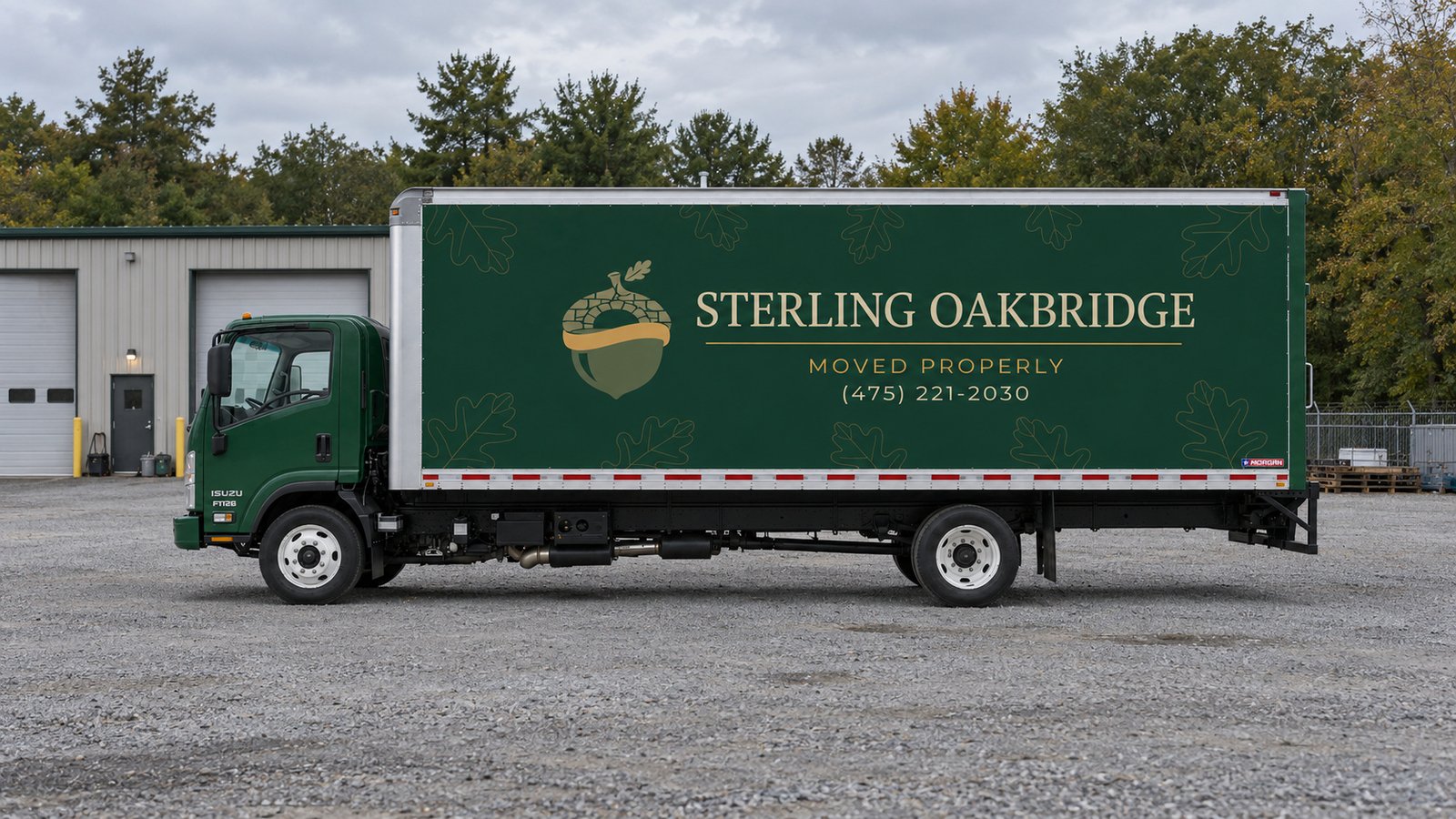 A complete green Sterling Oakbridge Isuzu FTR26 box truck standing on a level gravel receiving yard.