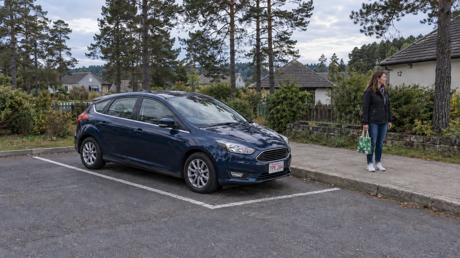 A complete blue hatchback in a marked parking bay beside a woman holding a shopping bag on a raised sidewalk.