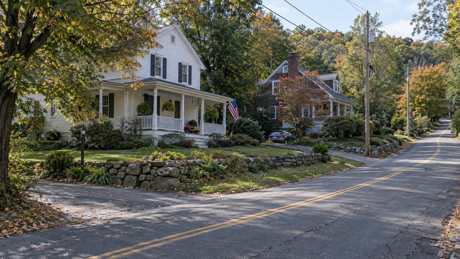 Older homes beside a gently climbing residential street with mature trees