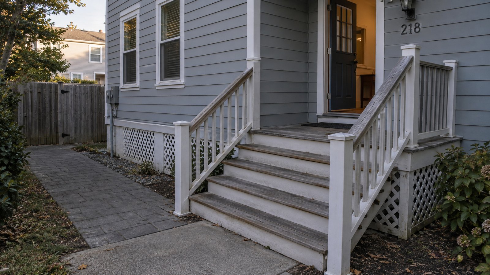 Reviewing a raised entrance Wooden porch steps and a landing leading to an open house door