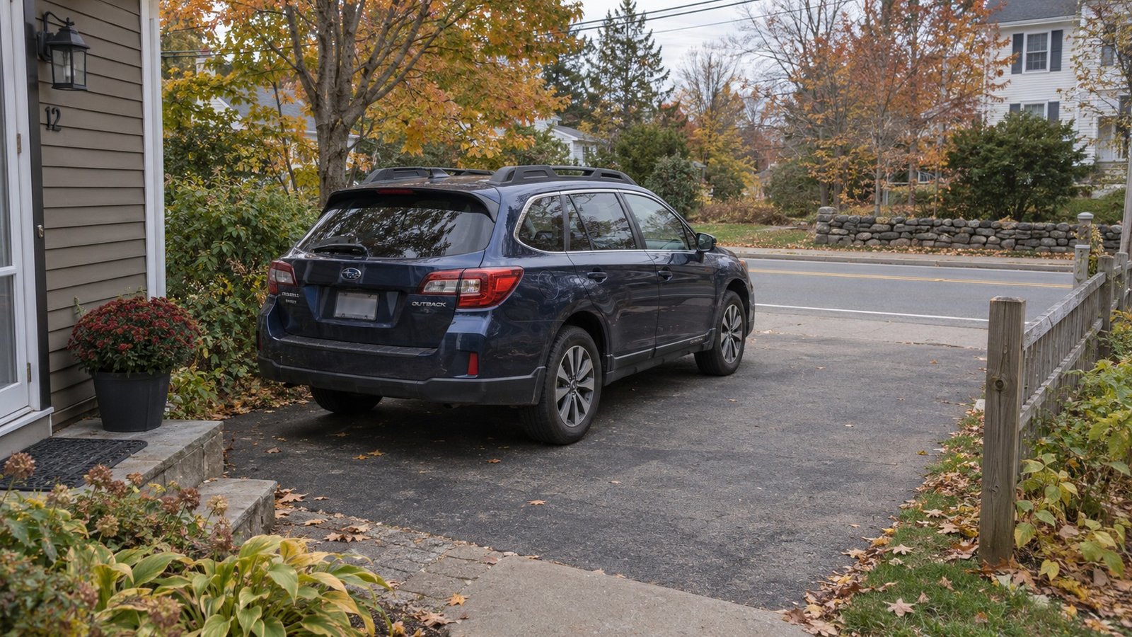 Try the complete everyday journey A complete ordinary dark-blue station wagon standing in a private drive that joins a continuing residential road.