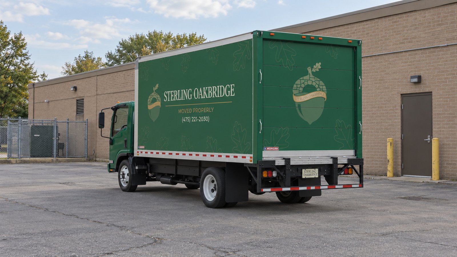 Vehicle space at the receiving property Green Sterling Oakbridge NPR16 truck parked in a paved receiving court behind a low brick building.