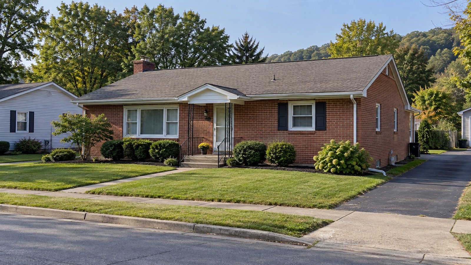 A brick home and its approach Single-story red-brick house with front steps, a path across the lawn and a paved side driveway