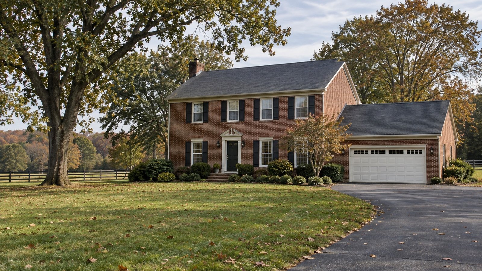 See the property and its approach A complete red-brick rural Colonial home with attached garage, paved driveway and mature oaks.