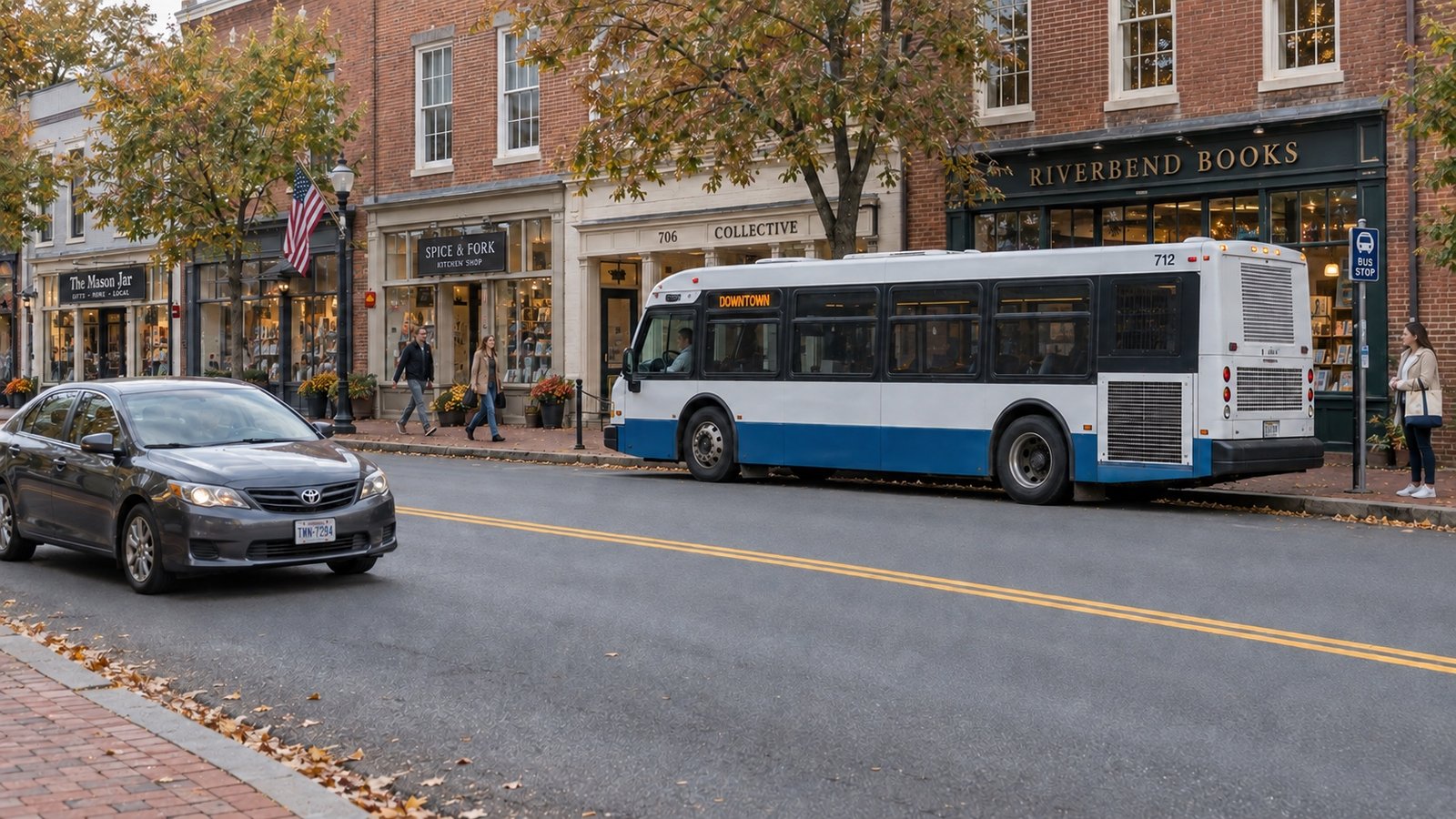 Blue and white bus at a brick storefront curb, with pedestrians and a gray car traveling in the opposite lane