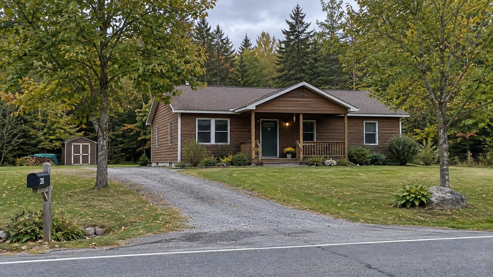 Planning a Holden home move A brown single-story house with a covered porch and a gravel driveway among trees