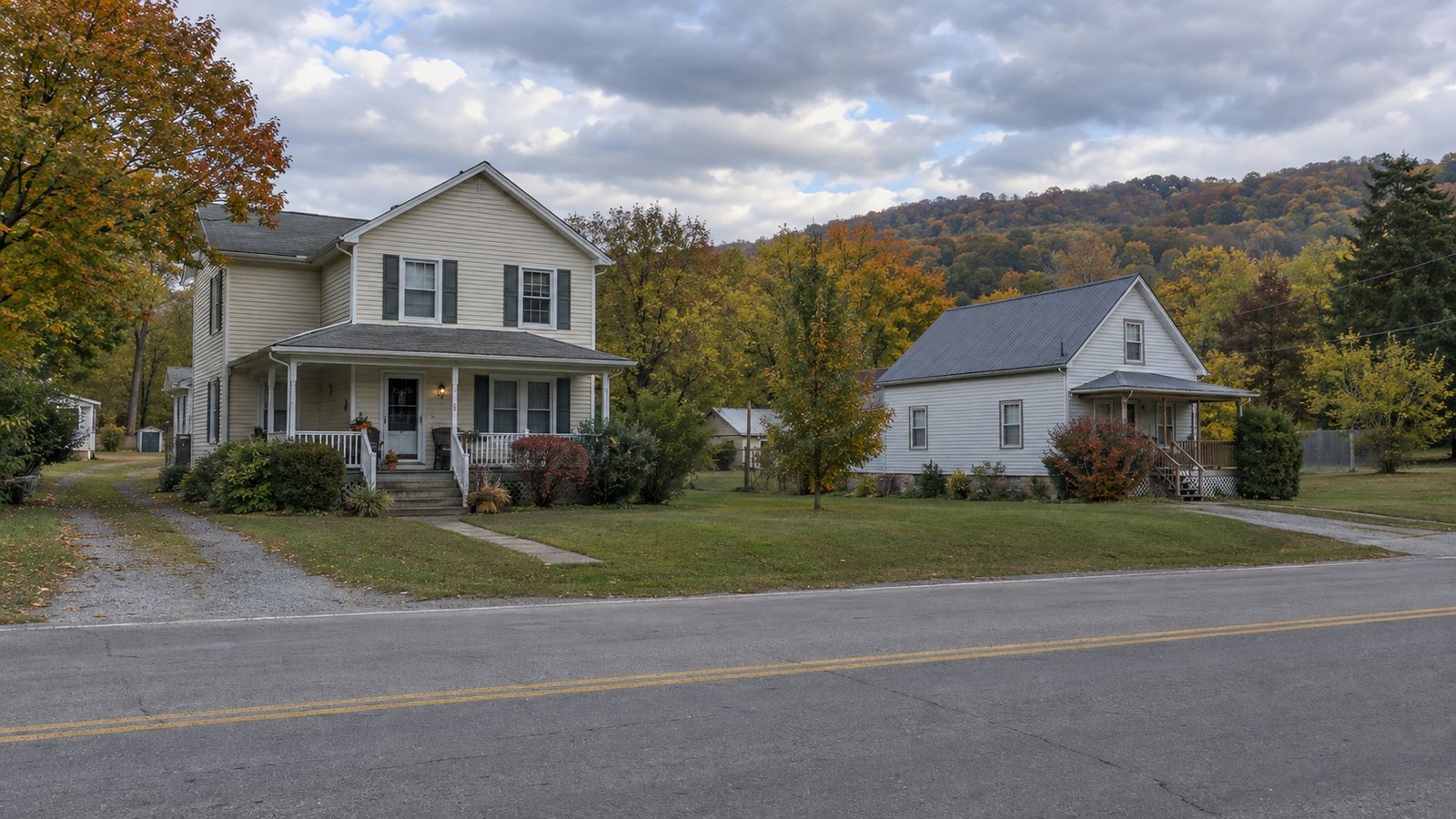 Explore the everyday setting Two modest wood homes beside a quiet residential road in autumn.