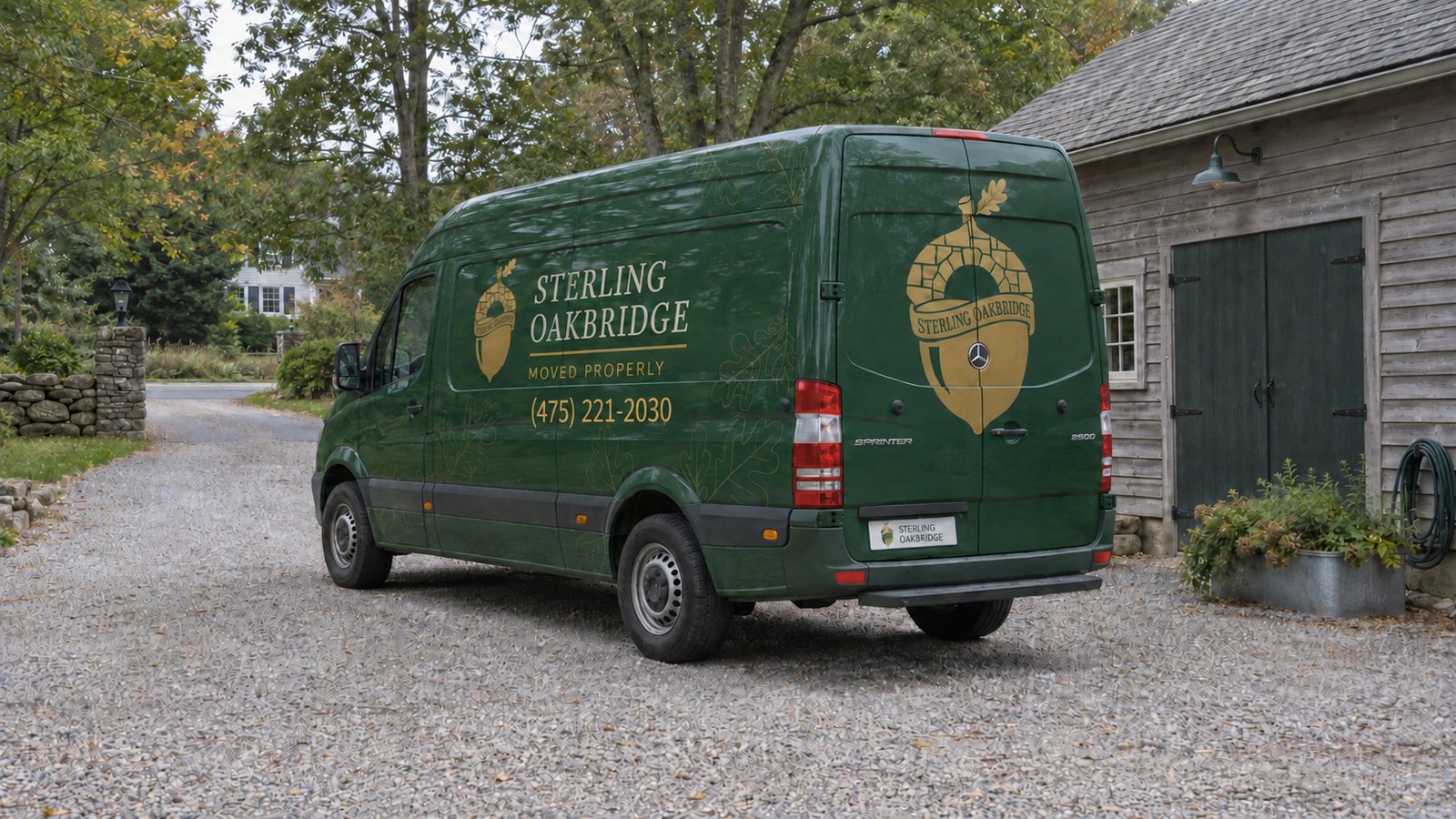 Agree the vehicle standing place Green Sterling Oakbridge Sprinter parked on gravel beside a wooden outbuilding, viewed from the rear left