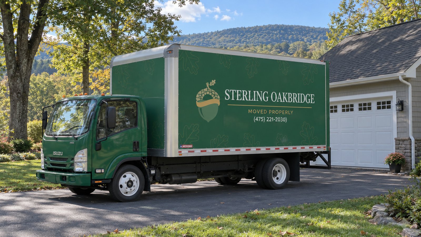 Confirm the assigned vehicle position A whole green Sterling Oakbridge Isuzu NPR16 on a paved driveway beside a garage.