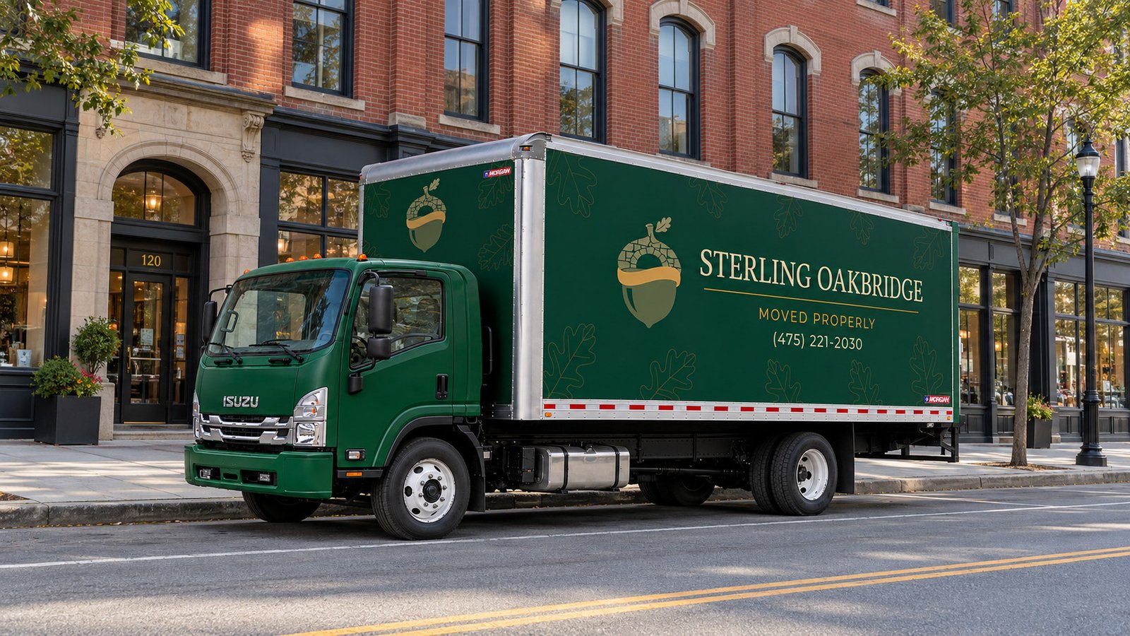 Green moving truck beside a brick mixed-use building and a clear sidewalk
