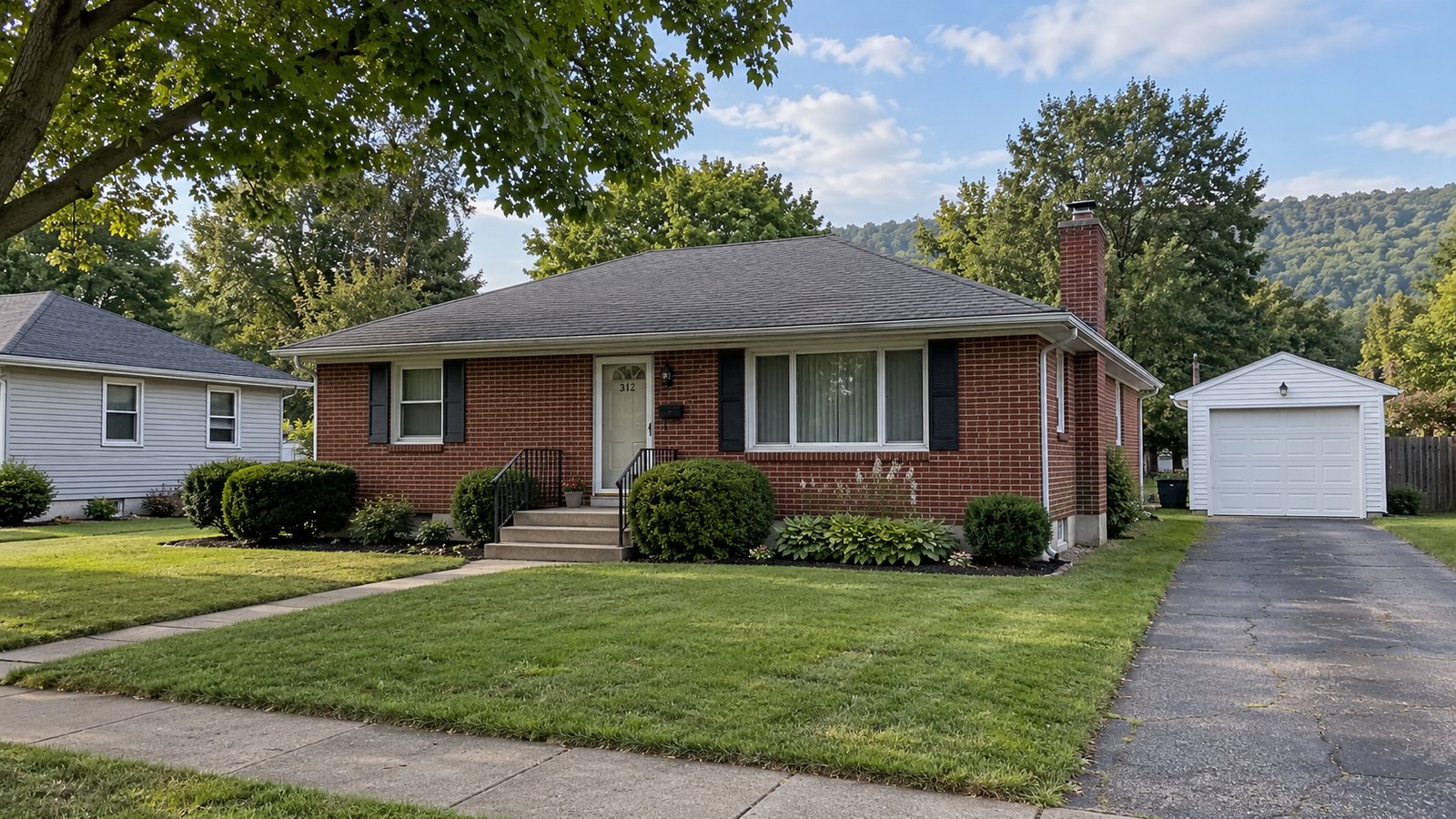 A Pennsylvania home and its separate garage A one-story red-brick house with a full hip roof, front steps and a driveway leading to a separate white garage.