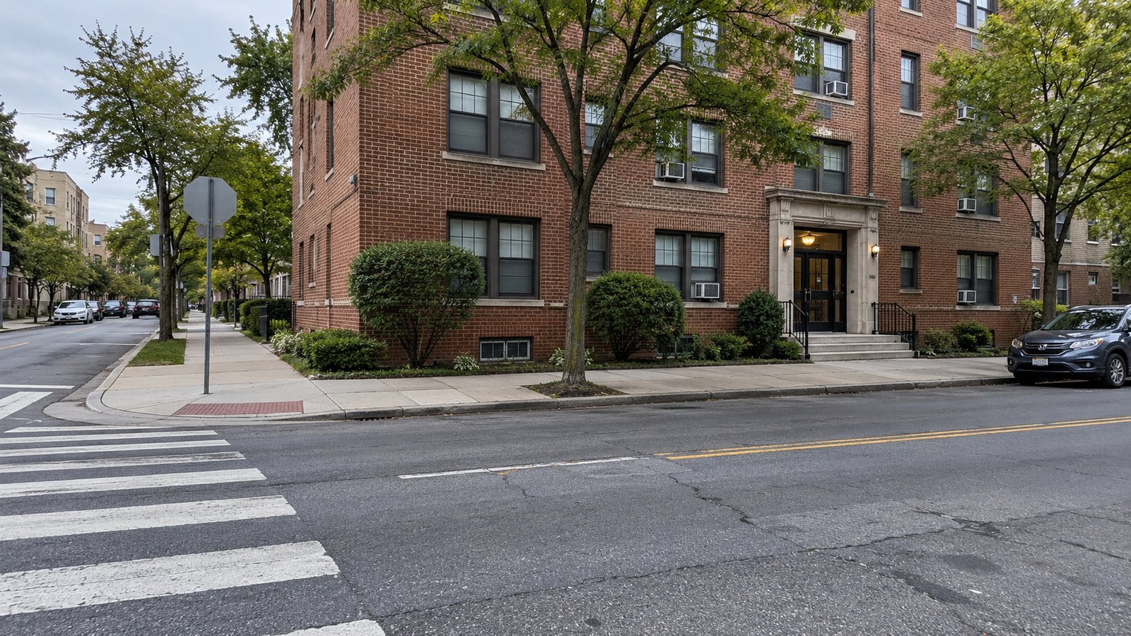 A proposed curb position near a crossing Apartment entrance and empty curb stretch beside a corner pedestrian crossing and curb ramp.
