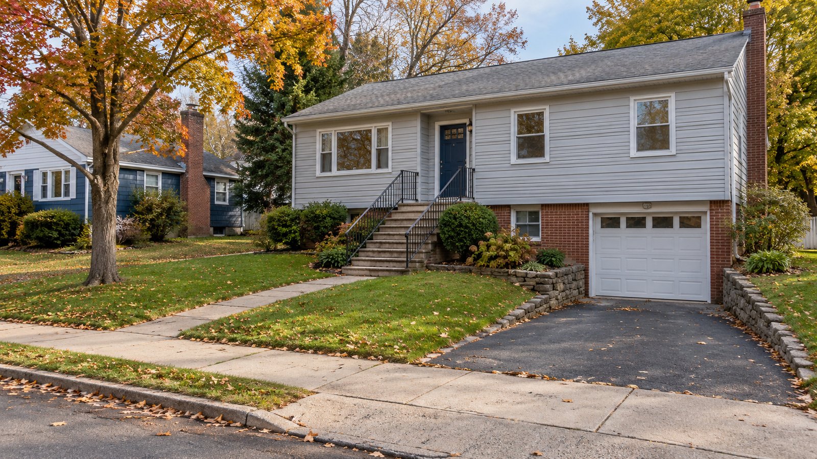 The house and its complete approach Raised-ranch home with a complete entrance stair and a separate lower garage driveway.