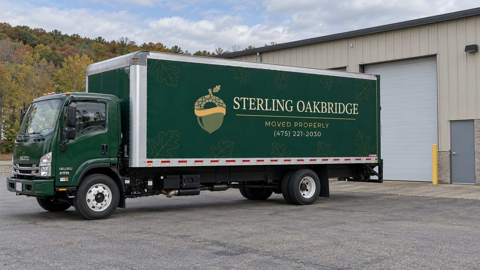 Space for a commercial delivery Dark green Sterling Oakbridge Isuzu FTR box truck on a paved court beside a light industrial building