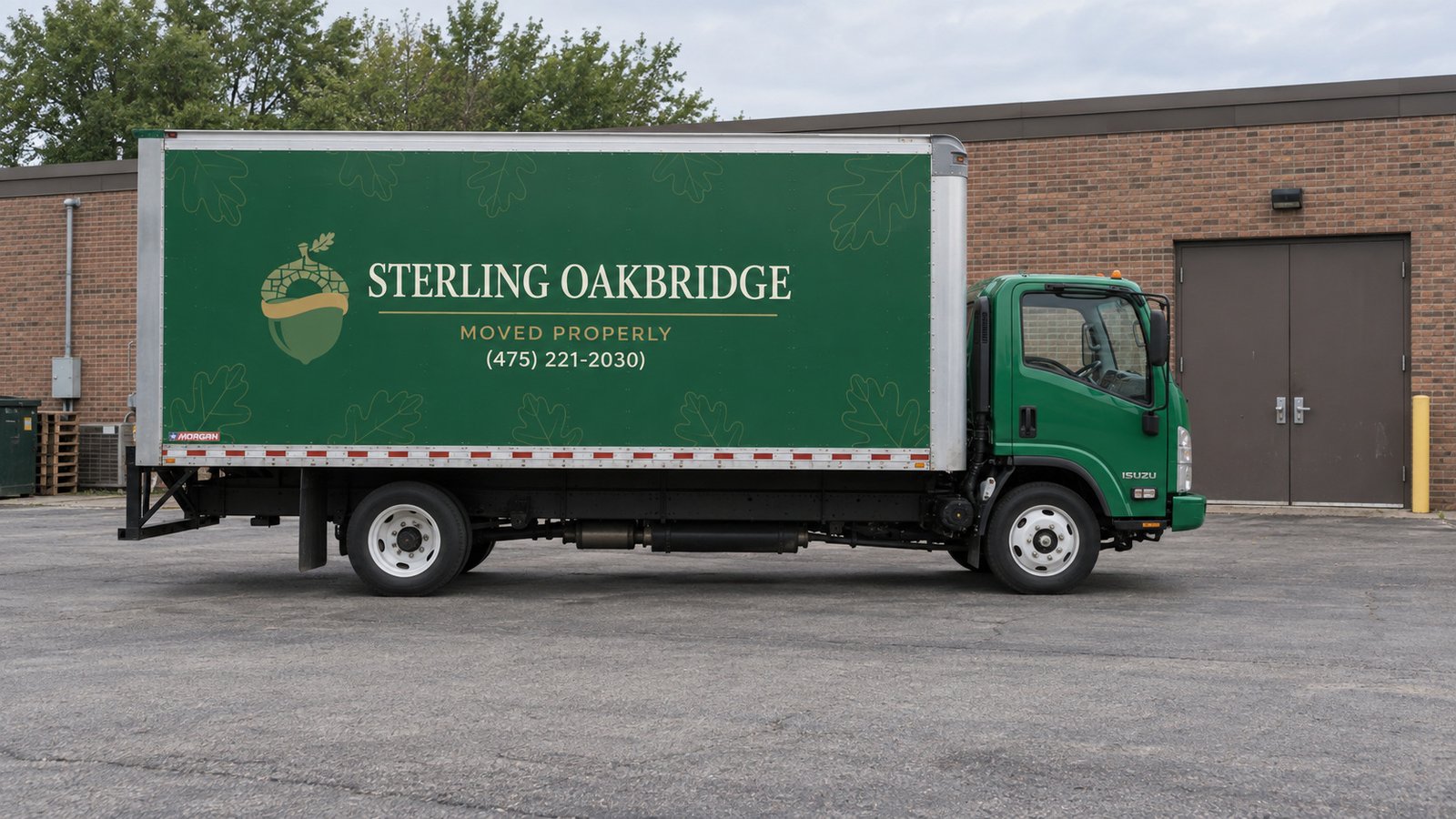Truck position at a private receiving court Green Sterling Oakbridge Isuzu box truck parked beside a brick workshop receiving door