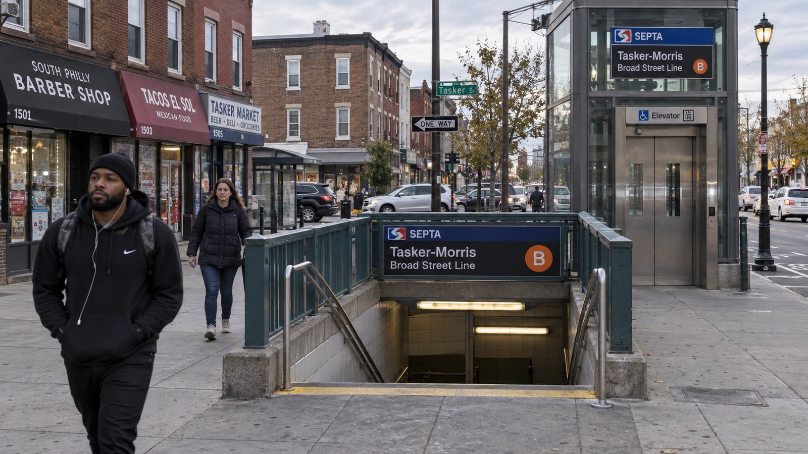 Pedestrians beside a SEPTA Broad Street Line subway entrance and elevator in a Philadelphia neighborhood.