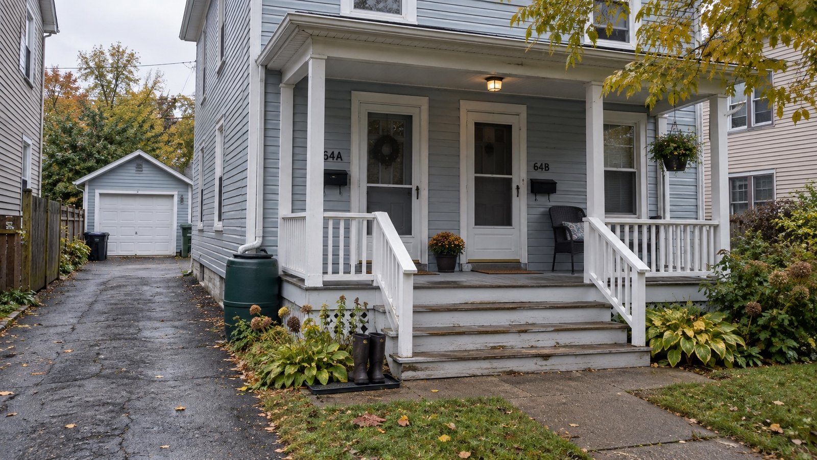 An older frame house with a shared porch and a narrow side driveway.