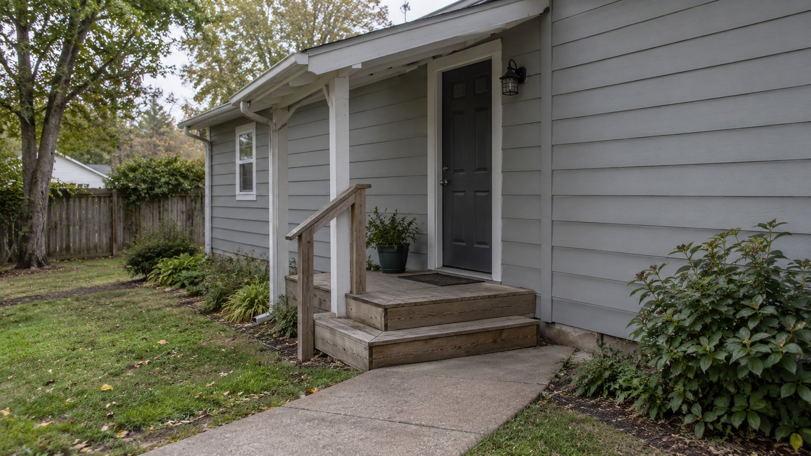 Follow the full entry route A complete ordinary covered wood side entry, short stair and connected concrete path.