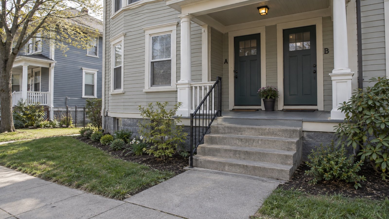 Broad steps leading to a covered porch with two marked unit doors