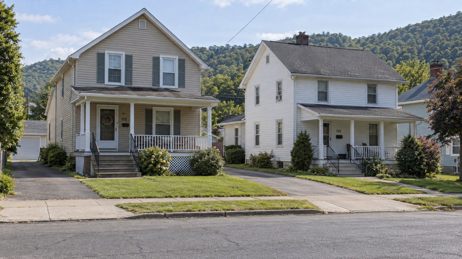 Inspect the property approach Two complete porch houses, steps and connected driveways with wooded valley hills beyond.