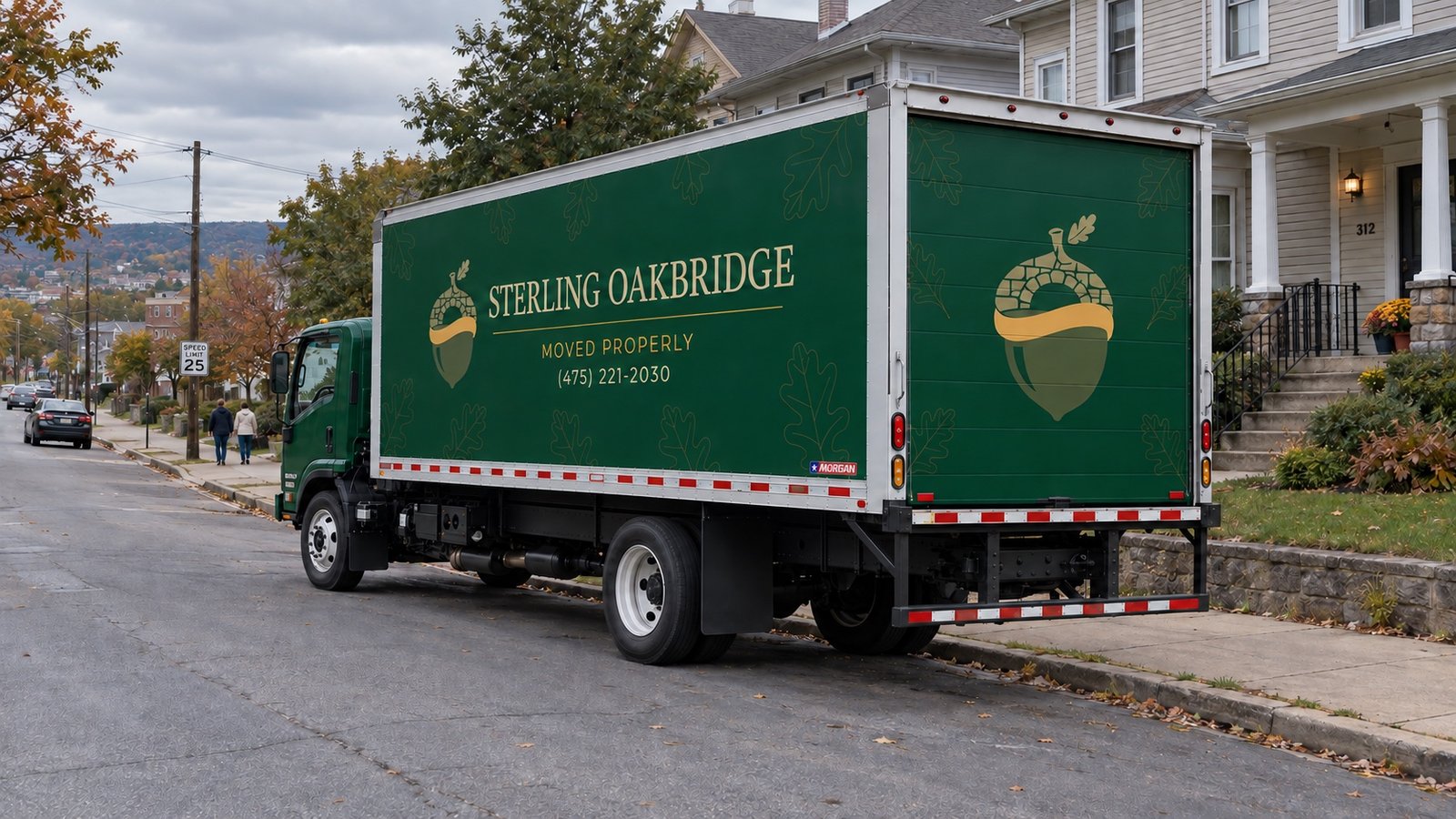 Moving truck beside the sloping curb A green Sterling Oakbridge FTR26 truck parked beside a residential curb, seen from its rear corner and side.