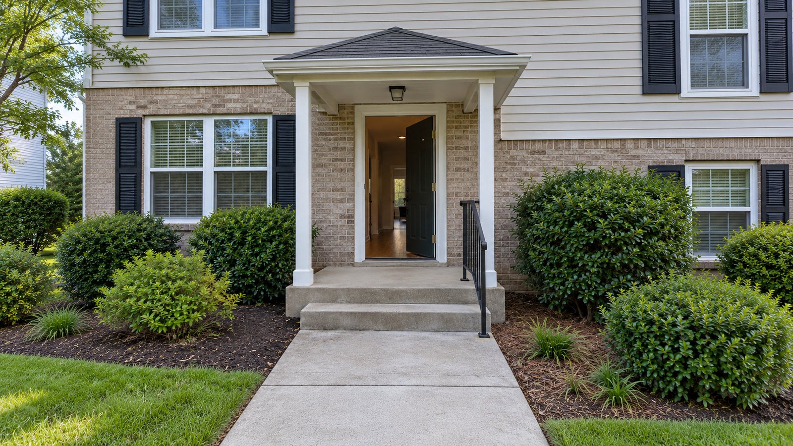 A complete entry route Two concrete steps lead to a covered landing and an open single entrance door.