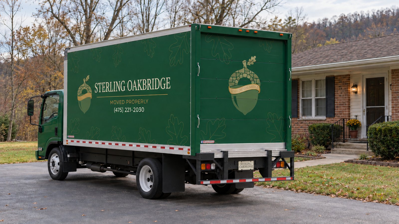 Working space behind the truck Dark green Sterling Oakbridge Isuzu box truck parked on a paved residential drive