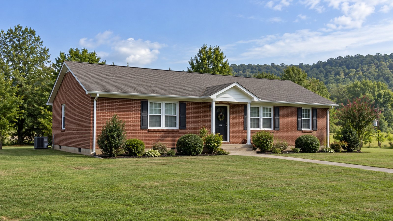 A home and its approach Single-story brick house with a small front porch, lawn and concrete path