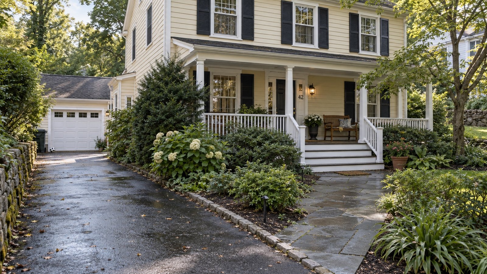 A maintained Colonial-style Stamford home with a side driveway and a clear path to a broad porch.