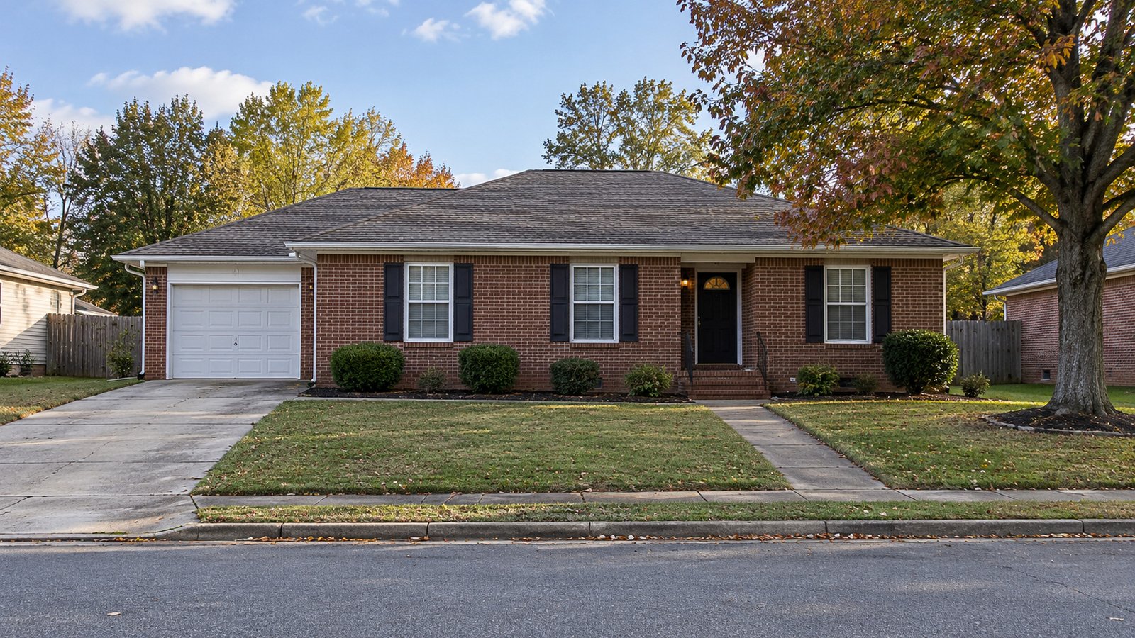 A single-storey brick house with a front path and an attached garage driveway.