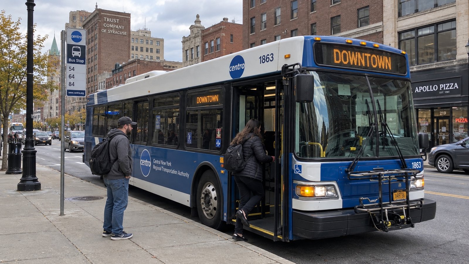 A downtown street with a city bus among older commercial buildings.