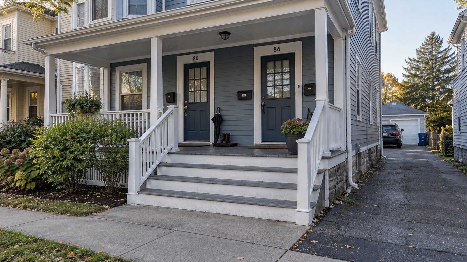 An older frame double with a shared porch and a narrow driveway.