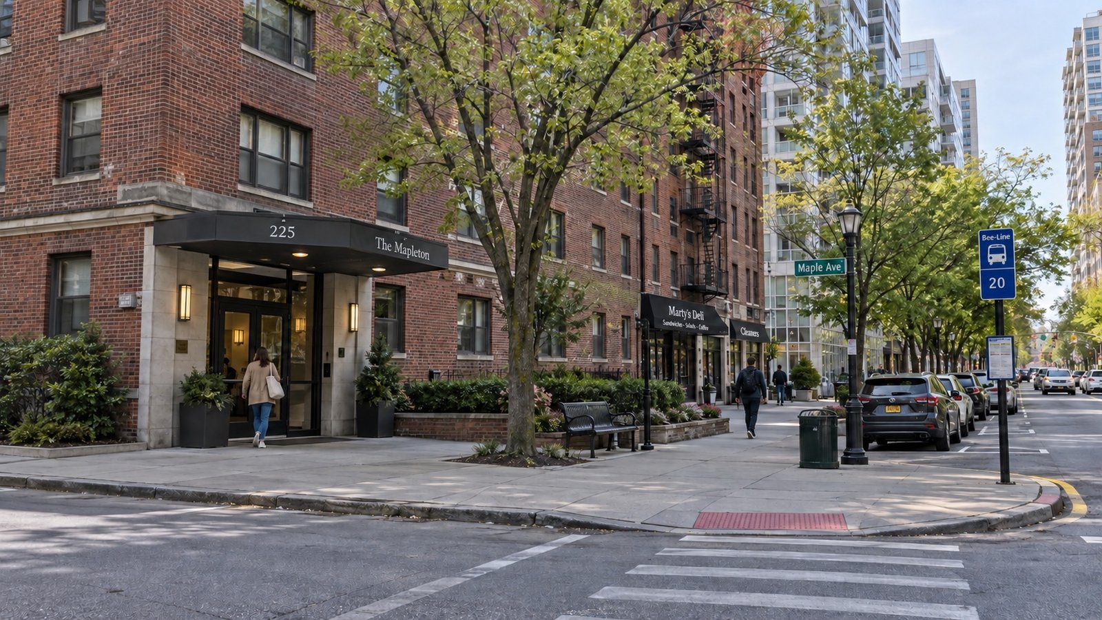 A downtown White Plains residential block with a mid-rise brick apartment building and a tree-lined sidewalk.