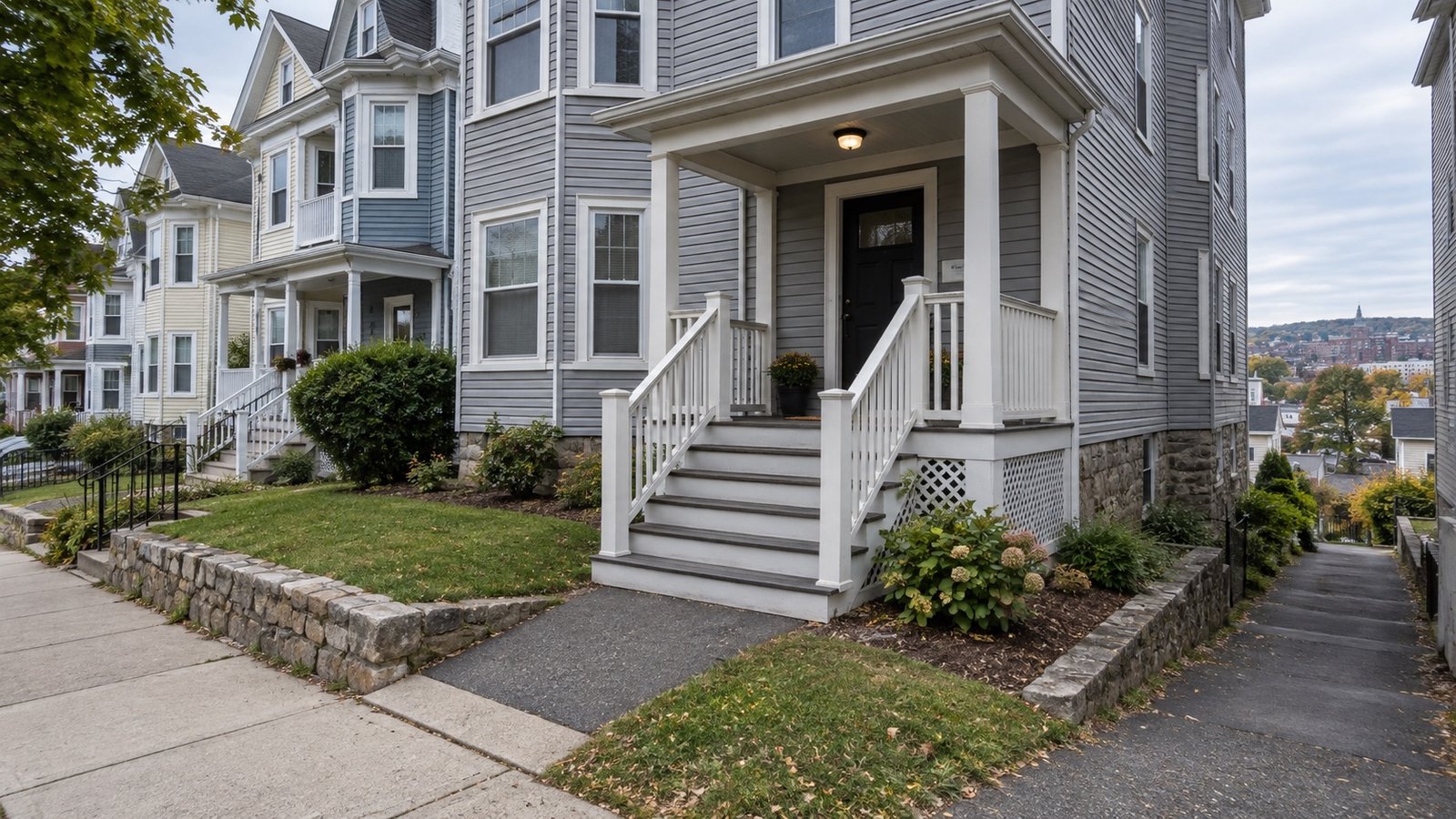Connected porch steps and railings leading from a paved walk to a house entrance
