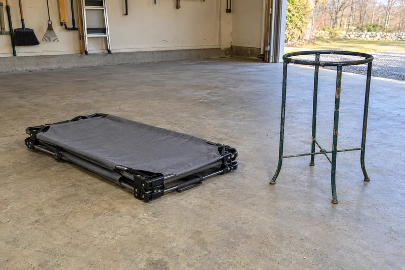 A folded camping cot and old metal plant stand reviewed before an illustrative Ringoes interstate move A folded camping cot and old metal plant stand reviewed before an illustrative Ringoes interstate move