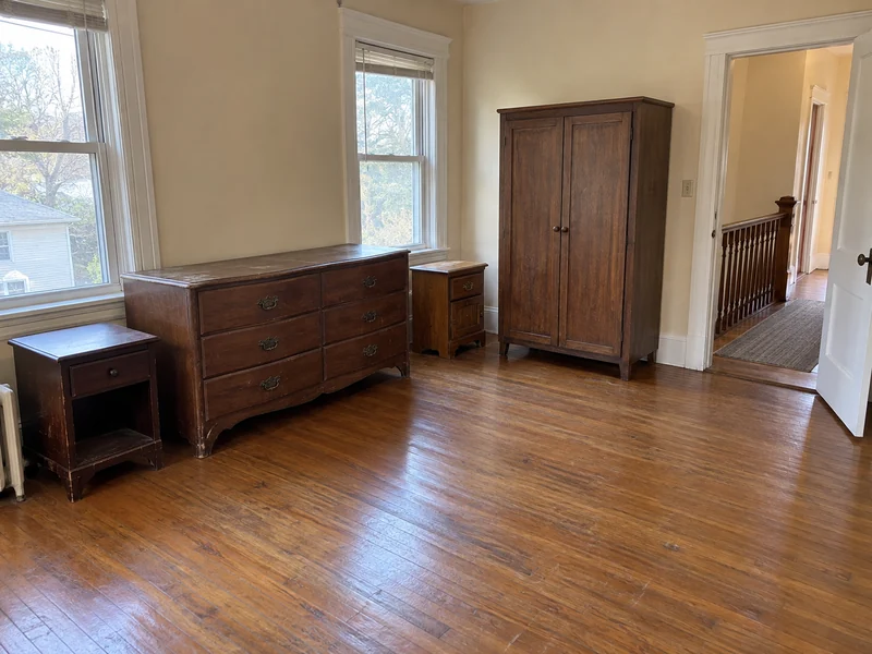 Dresser, wardrobe cabinet and mismatched nightstands in a clear upper-floor room An old dresser, wardrobe cabinet and two nightstands selected in a shared room with a clear exit