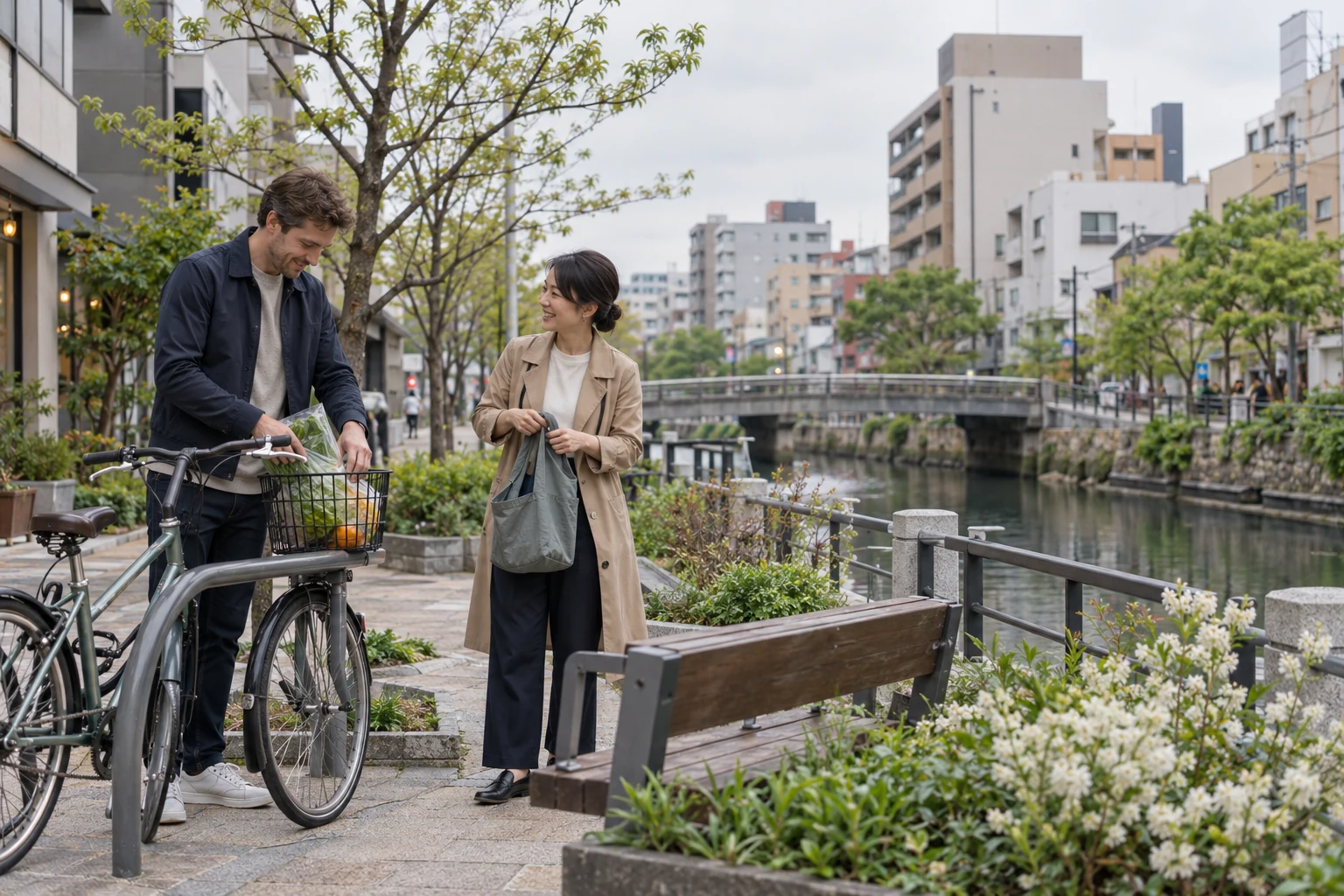 The grocery stop inside a Fukuoka city week Two adults pause beside a canal, one arranging groceries in a bicycle basket while the other holds a cloth bag.